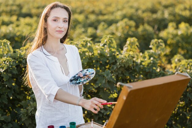 Confident young woman in the nature painting