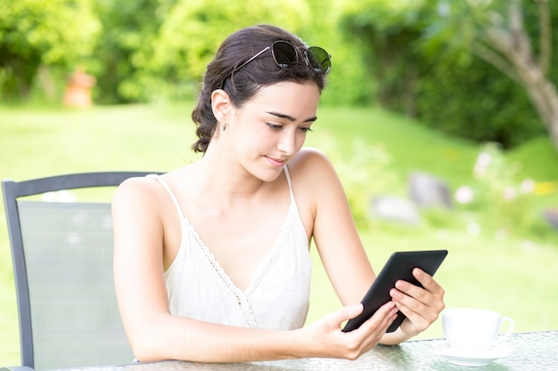 Confident young woman using digital tablet outdoor