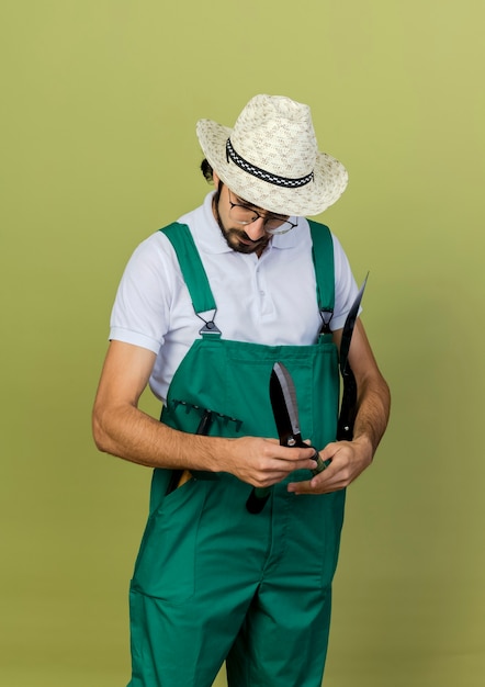 Confused gardener man in optical glasses wearing gardening hat