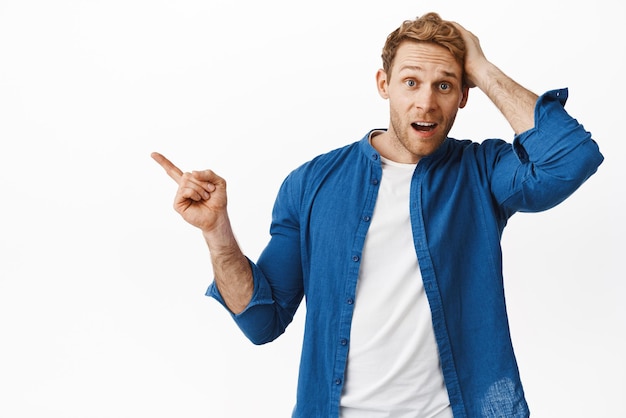 Free Photo confused guy scratch head and pointing left at something surprising looking questioned asking question about product banner standing over white background clueless