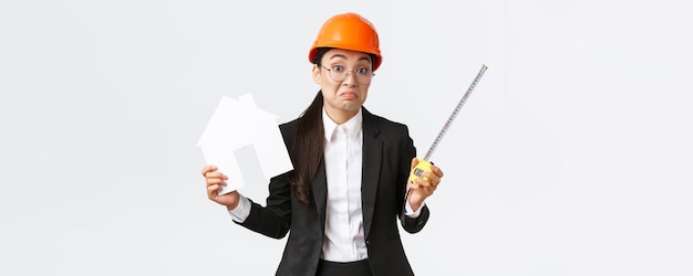 Confused indecisive asian female architect dont know what do engineer in helmet and business suit sh