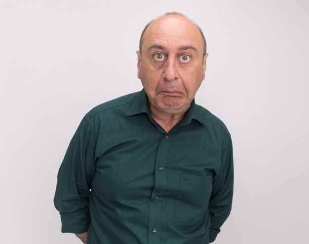 Confused  middle-aged man wearing green t-shirt isolated on white wall