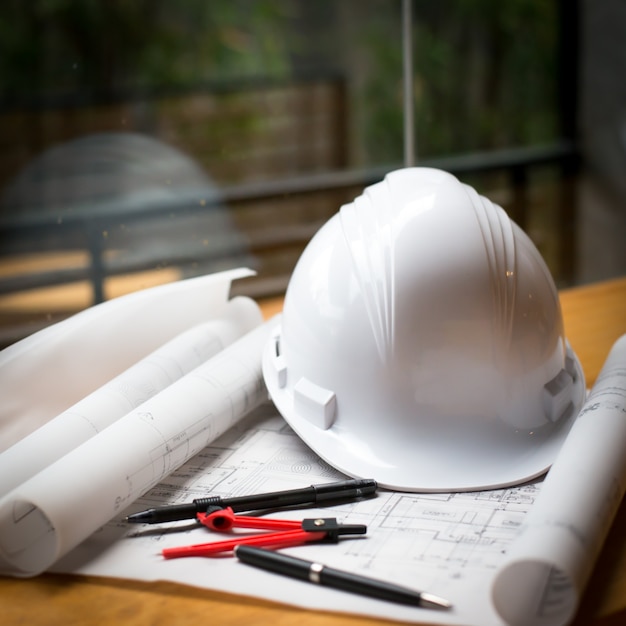 construction concept image helmet rolled blueprints on wooden boards in retro style.