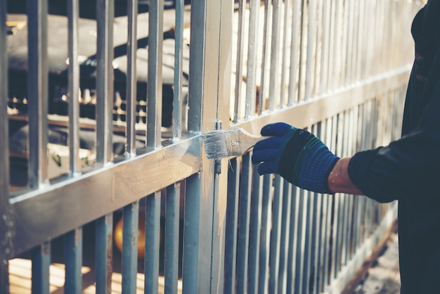 Free photo construction worker painting fence at home