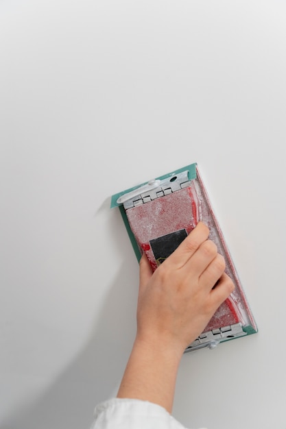 Free photo construction worker smoothing wall with tool