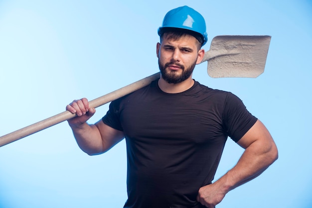 Free photo construction worker with blue helmet holding the equipment