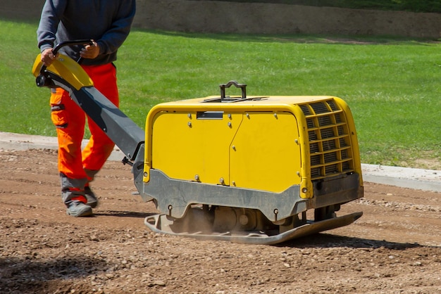 Free Photo construction worker working on the road with a vibratory plate