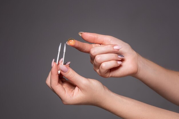 Contact eye lens. Close-up of woman holding white eye lense on finger. Health and eyes care concept