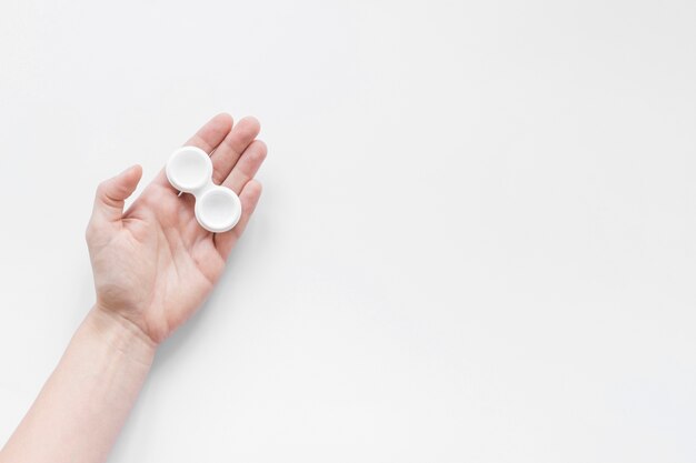 Container for lenses in hand on a white background