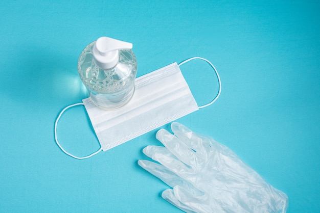 Free photo container with alcohol gel, gloves and surgical mask