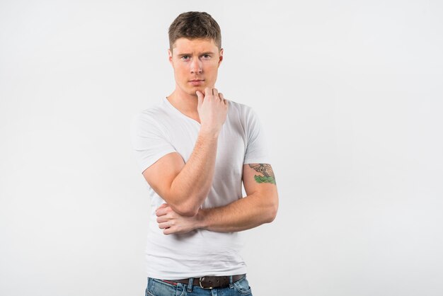 Contemplated young man against white backdrop