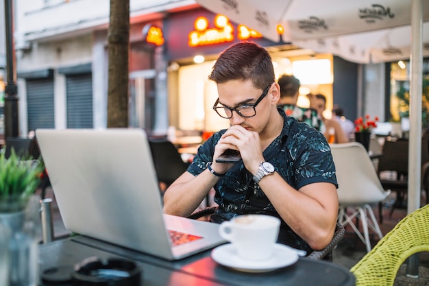 Free photo contemplated young man sitting in caf�