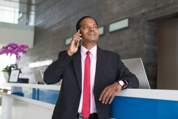 Content Business Man Calling on Phone at Reception