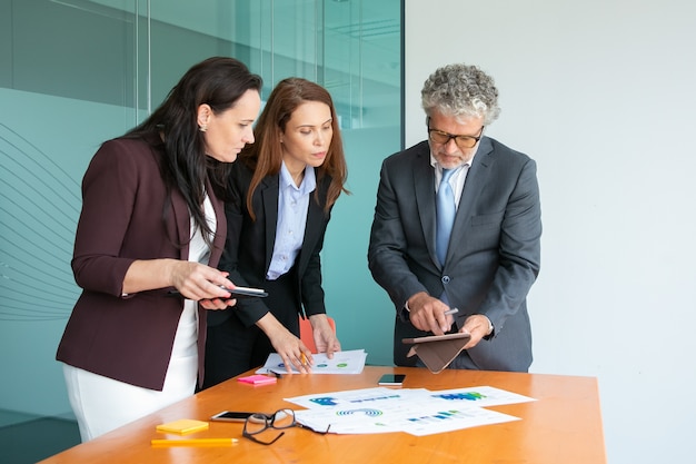 Content businesspeople watching data on tablet screen