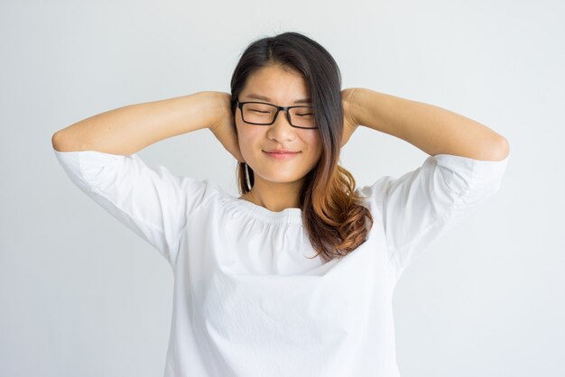 Content carefree Chinese girl covering ears with hands. 