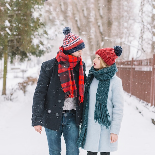 Content couple walking in snowfall