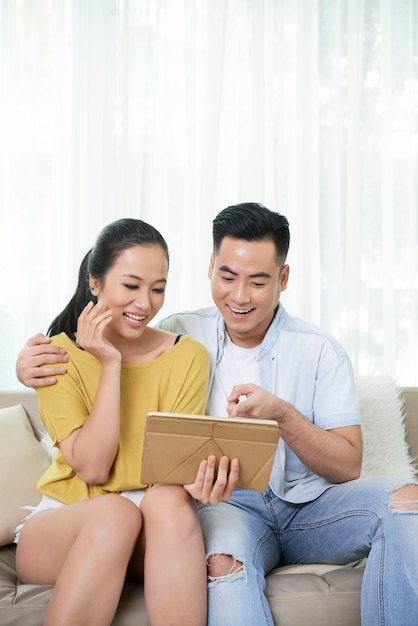 Content couple watching tablet and laughing