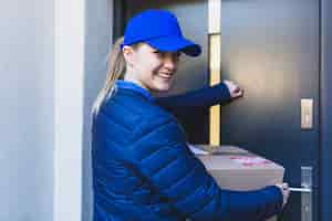 Free photo content female courier knocking on door