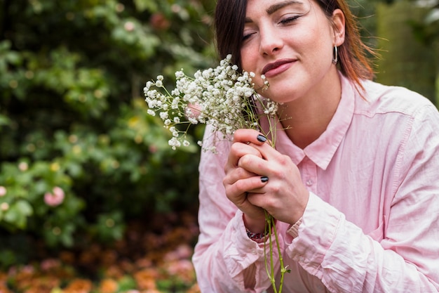 Content girl with white flowers in park 