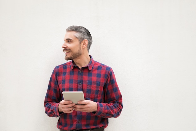 Content man with digital tablet looking aside