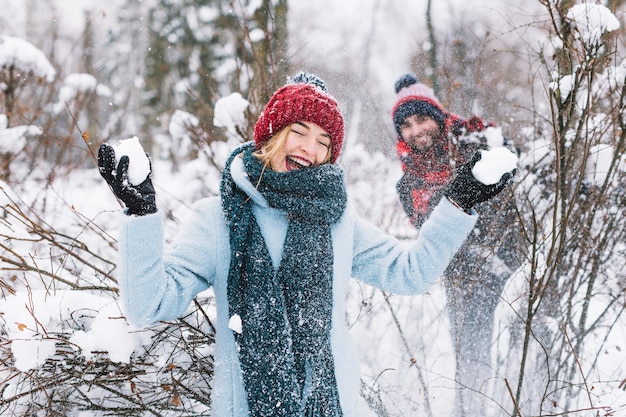 Free photo content man and woman playing snowballs