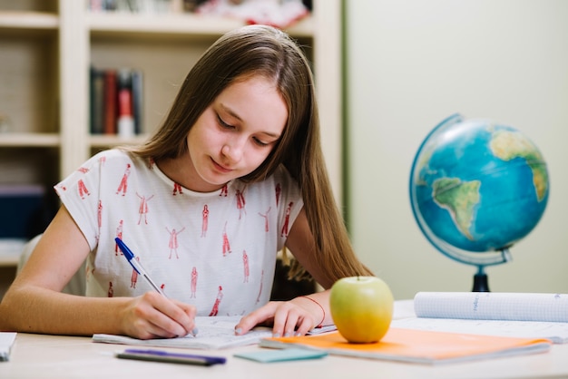 Content schoolgirl studying at table