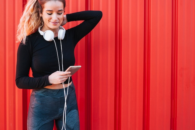 Content sportswoman using phone on street