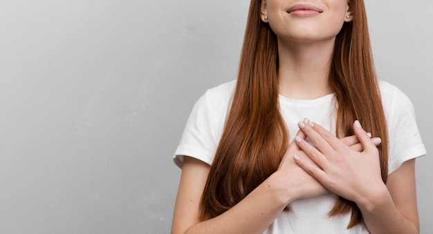 Content woman with hands on chest