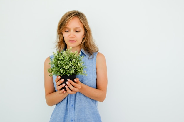 Free Photo content young beautiful woman holding pot plant