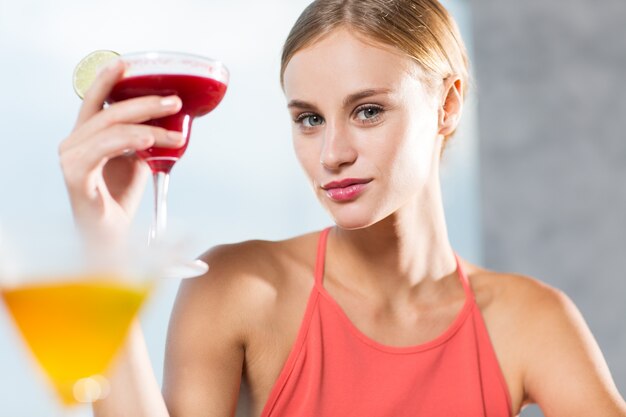 Content Young Woman Raising Glass of Cocktail