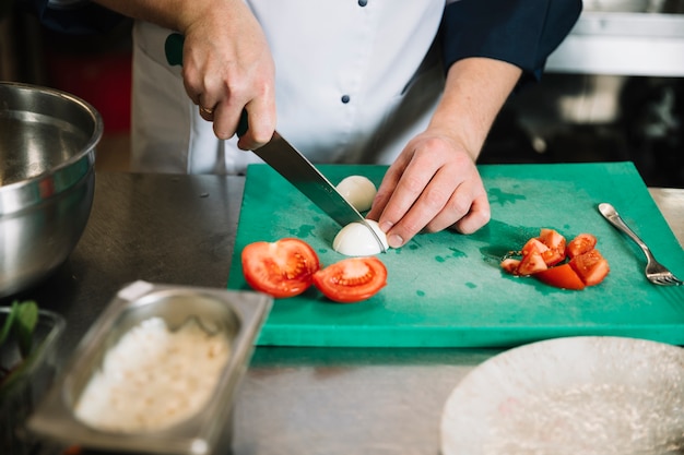 Free photo cook cutting boiled egg on board