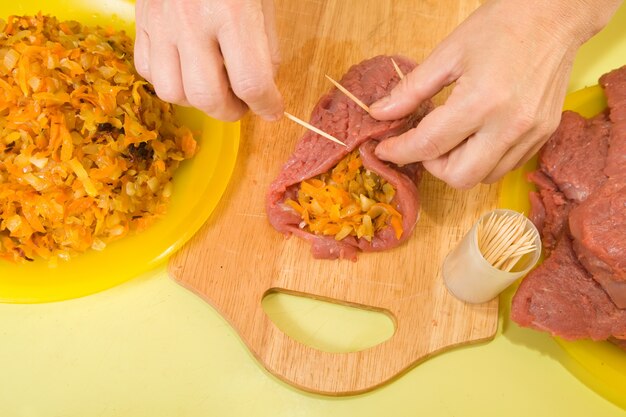 cook sewing stuffed beef by toothpicks