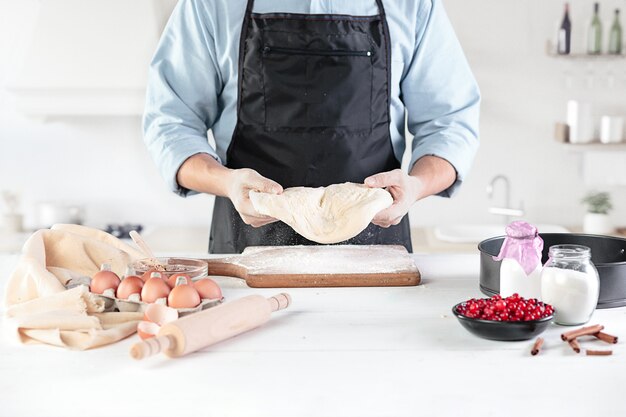 A cook with eggs on a rustic kitchen against the wall of men's hands