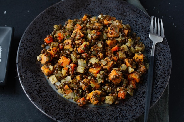 Free photo cooked black lentil with pumpkin served on plate. closeup