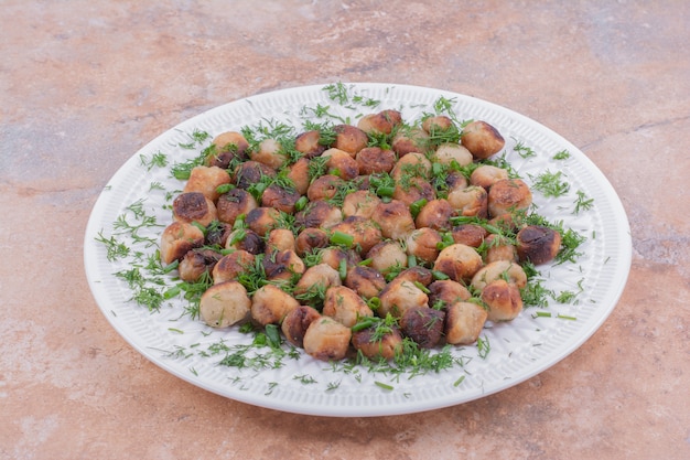 Cooked caucasian khinkali in white dish served with herbs and spices.