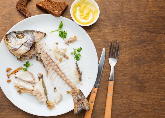 Cooked fish leftovers and cutlery