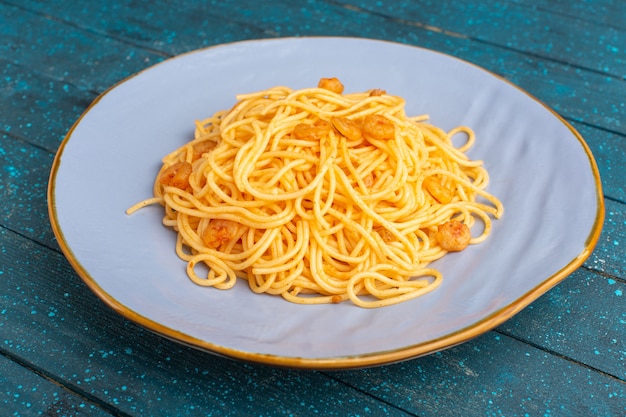 cooked italian pasta tasty inside ice-colored plate on blue wooden rustic