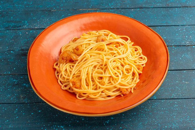 cooked italian pasta tasty inside orange plate on blue wood