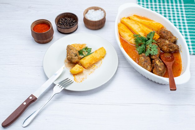 cooked meat cutlets with sauce potatoes and greens seasonings on white desk, food meal meat vegetable