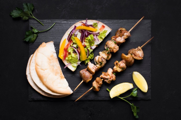 Free photo cooked meat and veggies kebab on black background