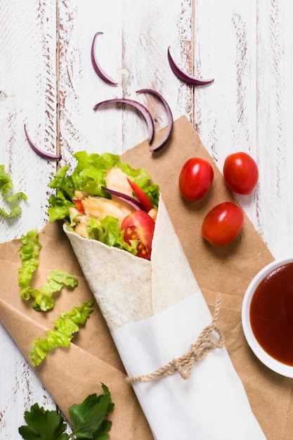 Free photo cooked meat and veggies kebab wrapped in paper