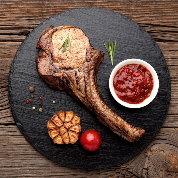 Free photo cooked meat with sauce on wooden board