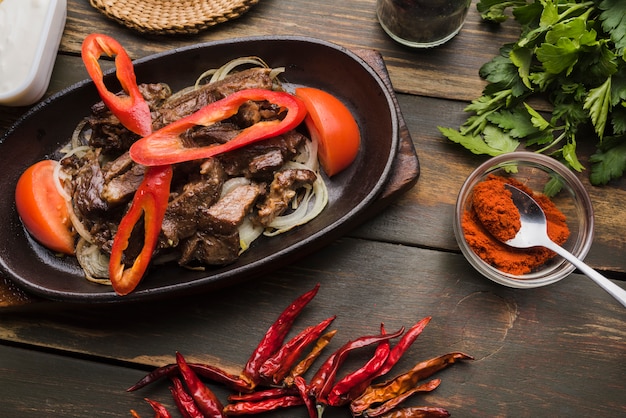 Cooked meat with tomatoes and peppers in pan 