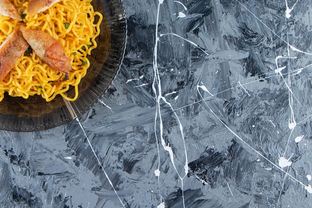 Free photo cooked noodle on a glass dish, on the marble background.