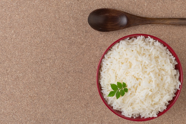 Free Photo cooked rice in a red cup placed on the plywood floor.