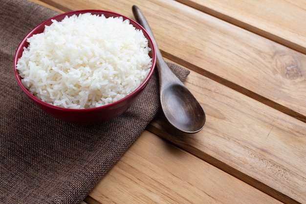 Free Photo cooked rice in a red cup placed on the plywood floor.