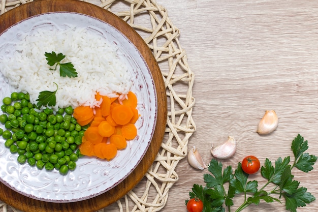 Free Photo cooked rice with vegetables and parsley on plate on wooden table