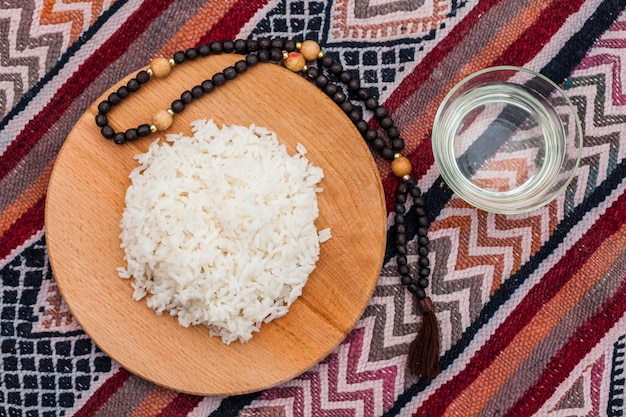 Free Photo cooked rice on wooden board with beads 