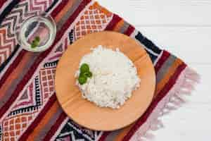 Free photo cooked rice on wooden board with water