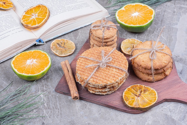 Cookie varieties on a wooden board with cinnamon and oranges